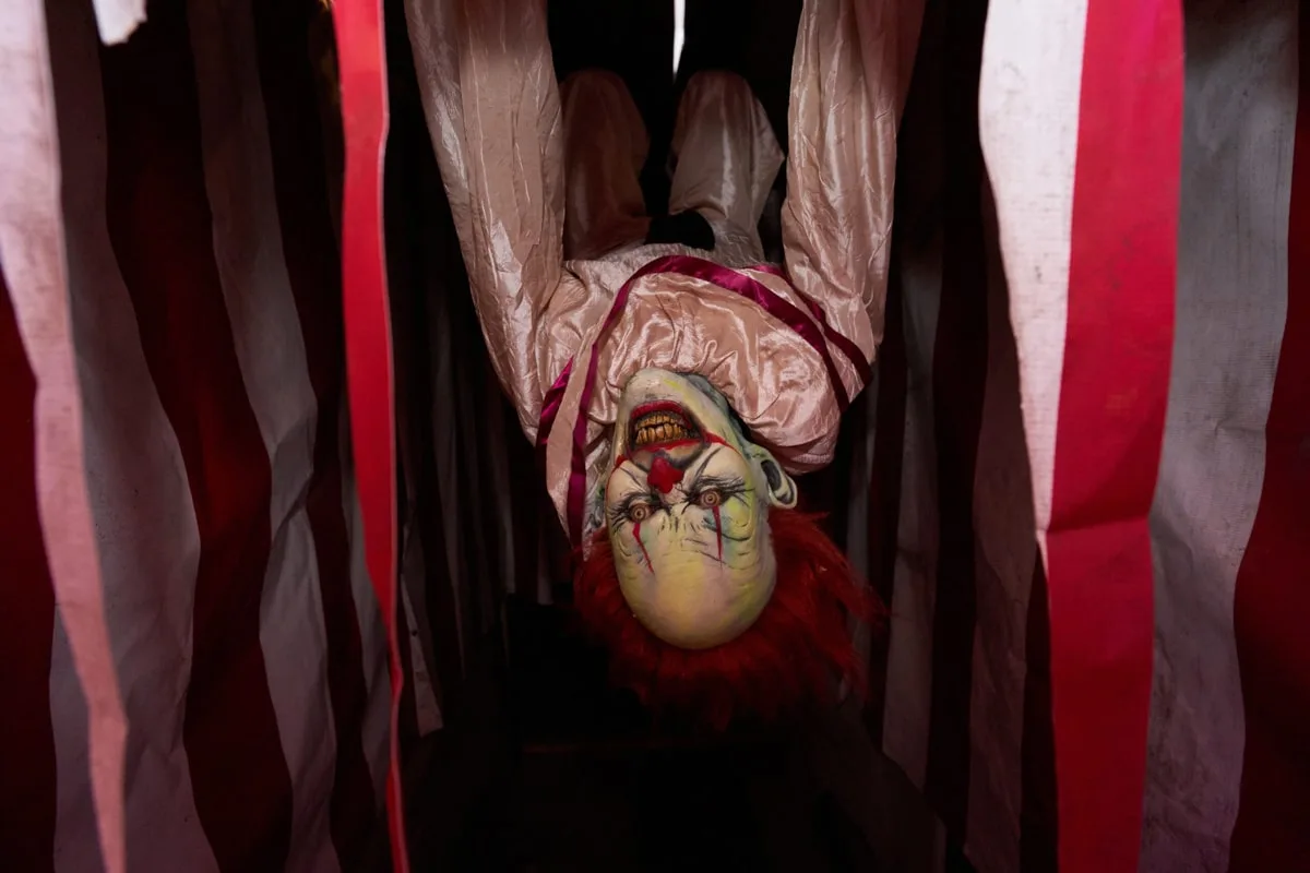 scary IT clown hanging upside down 