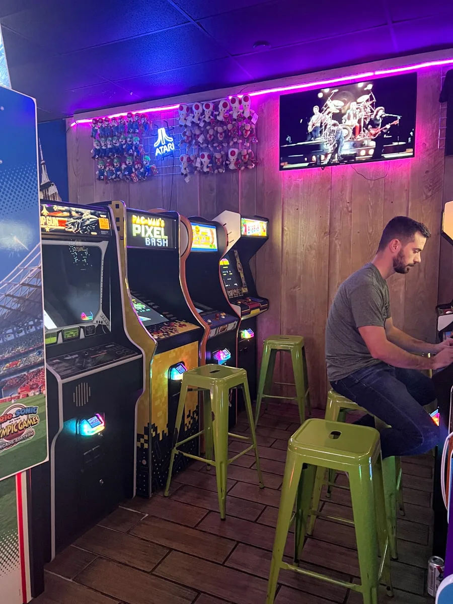 man playing arcade games in downtown johnson city at play it again retro arcade