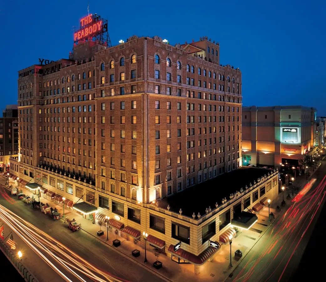 the peabody memphis hotel in downtown memphis at night with cars driving by the hotel
