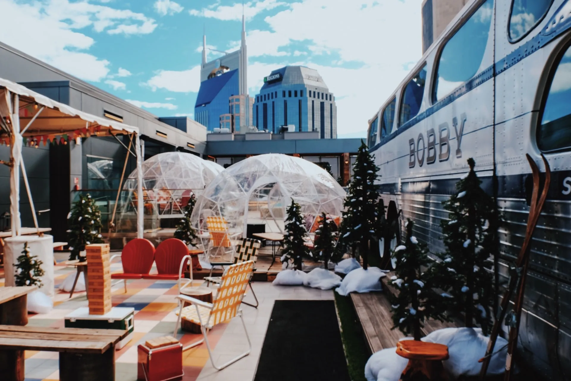 bobby hotel rooftop bar in nashville with outdoor igloos and bus overlooking nashville skyline