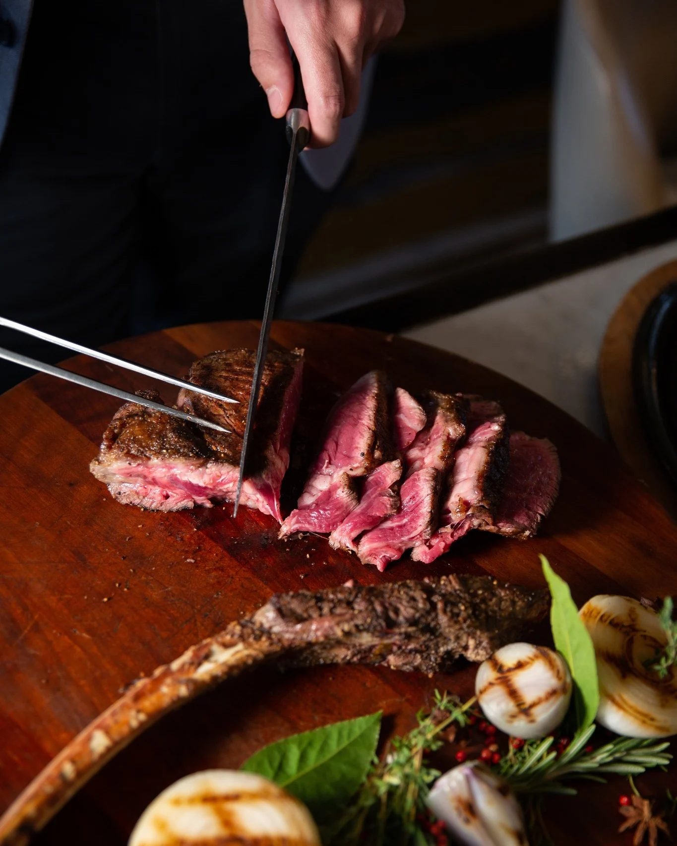 chef cutting into a piece of steak at bourbon steak restaurant in nashville tn 