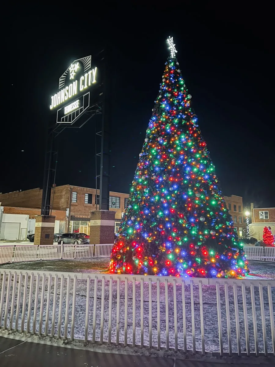 large christmas tree at night lit up in front of the johnson city tn sign in downtown johnson city for Christmas in Tennessee
