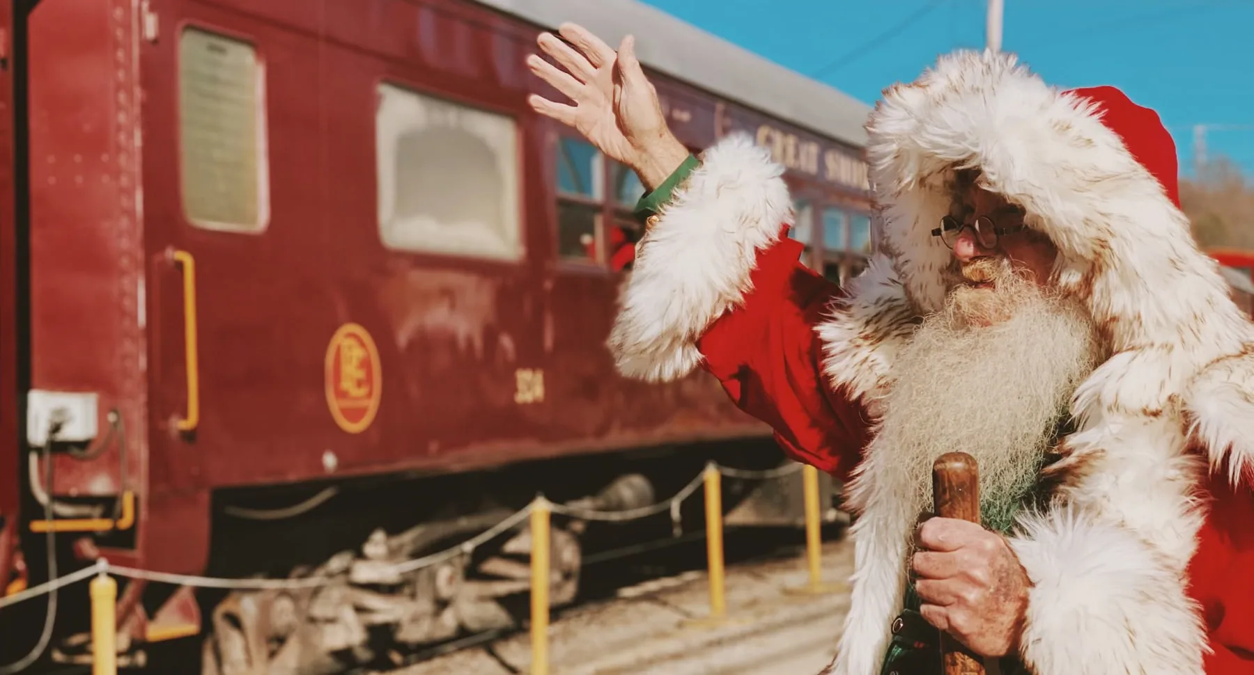 santa standing in front of the great smoky mountain train at christmas 
