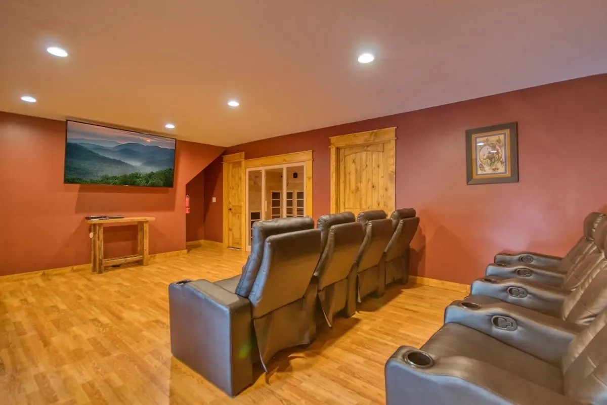 a cabin with a home movie theatre with a large screen tv and comfortable reclining seats