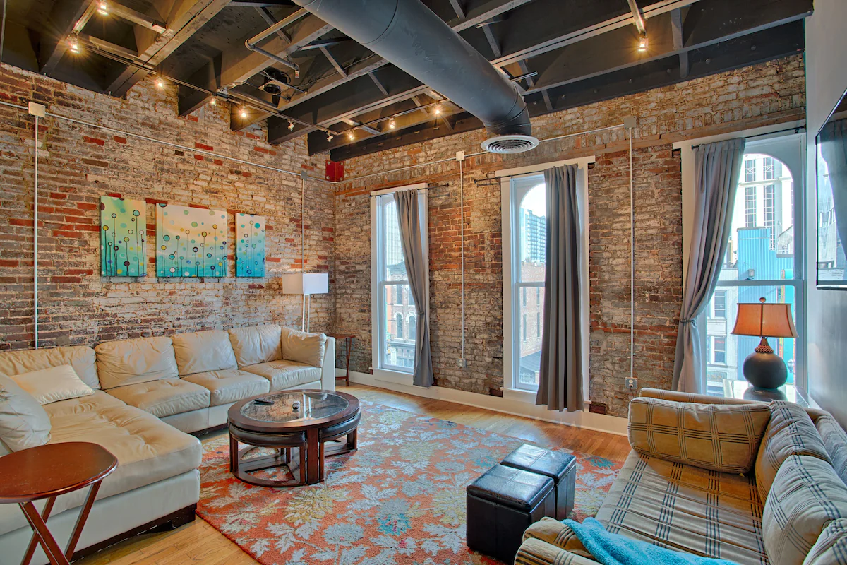 a large industrial style living room with brick overlooking honky tonk row in downtown nashville tn 