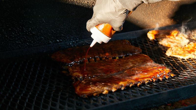 The smell of barbecue smoke coming from a roadside joint
