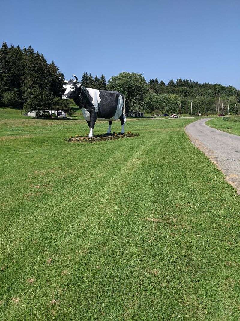 A Giant Cow Waiting Beside a Quiet Road