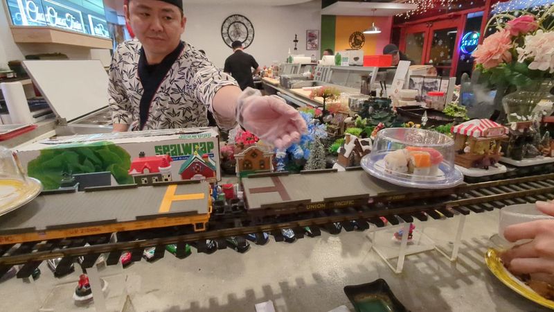 A Horn-Tooting Toy Train Carries Sushi Around the Bar A Horn-Tooting Toy Train Carries Sushi Around the Bar