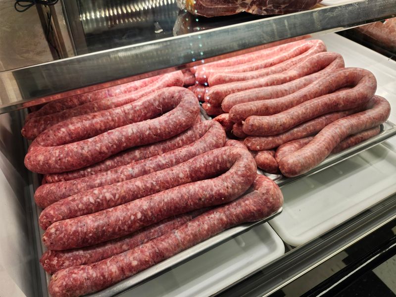Fresh Sausage, Prepared Pasta, and Cookie Trays in the Back Fresh Sausage, Prepared Pasta, and Cookie Trays in the Back