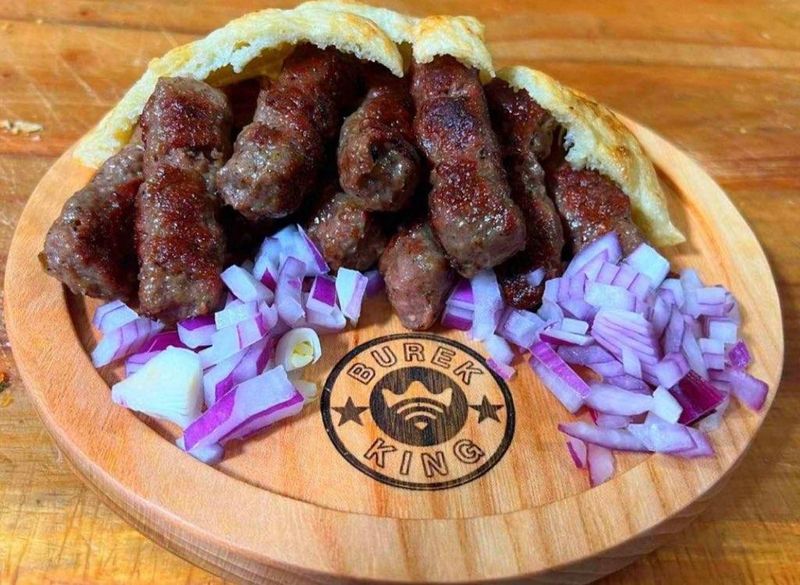 Char-Grilled Cevapi Arrive With Warm Lepinja and Raw Onion