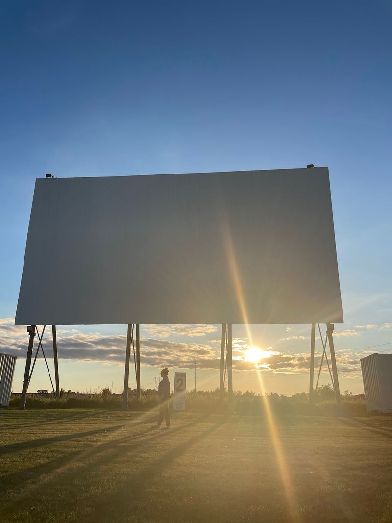 Two Glowing Screens Rising Over Gibson City Farmland